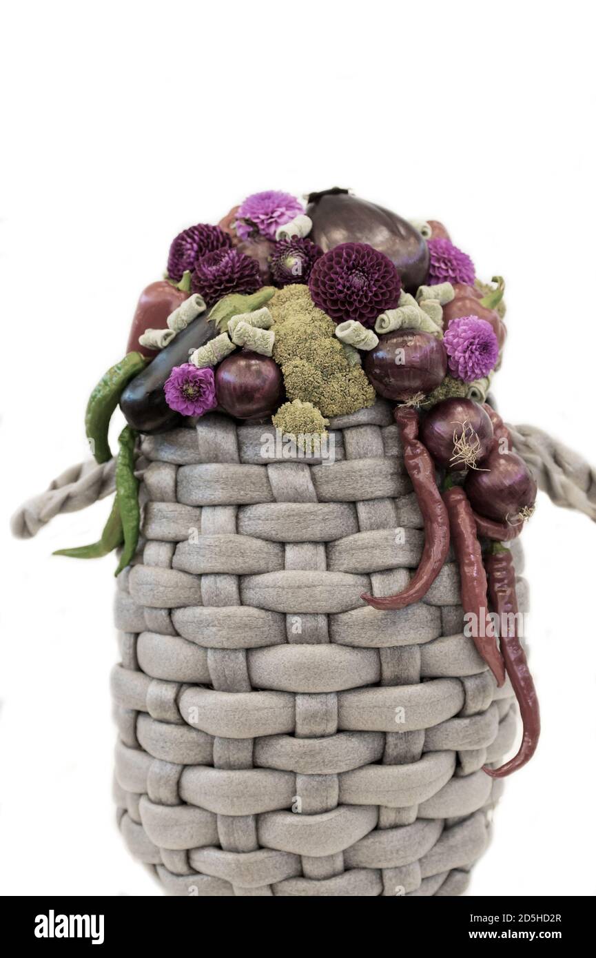belle décoration composition florale ou bouquet de légumes de saison poivron vert et rouge. avec ail et oignon et fleurs de chrysanthème pourpres dans un panier isolé sur fond blanc. Banque D'Images