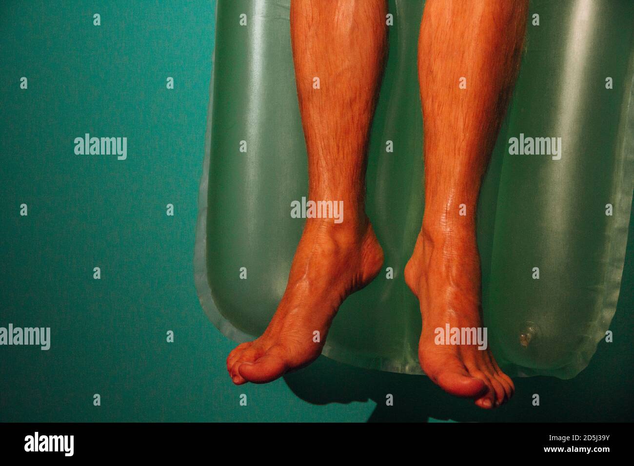 Gros plan des pieds d'un homme allongé sur un gonflable matelas Banque D'Images
