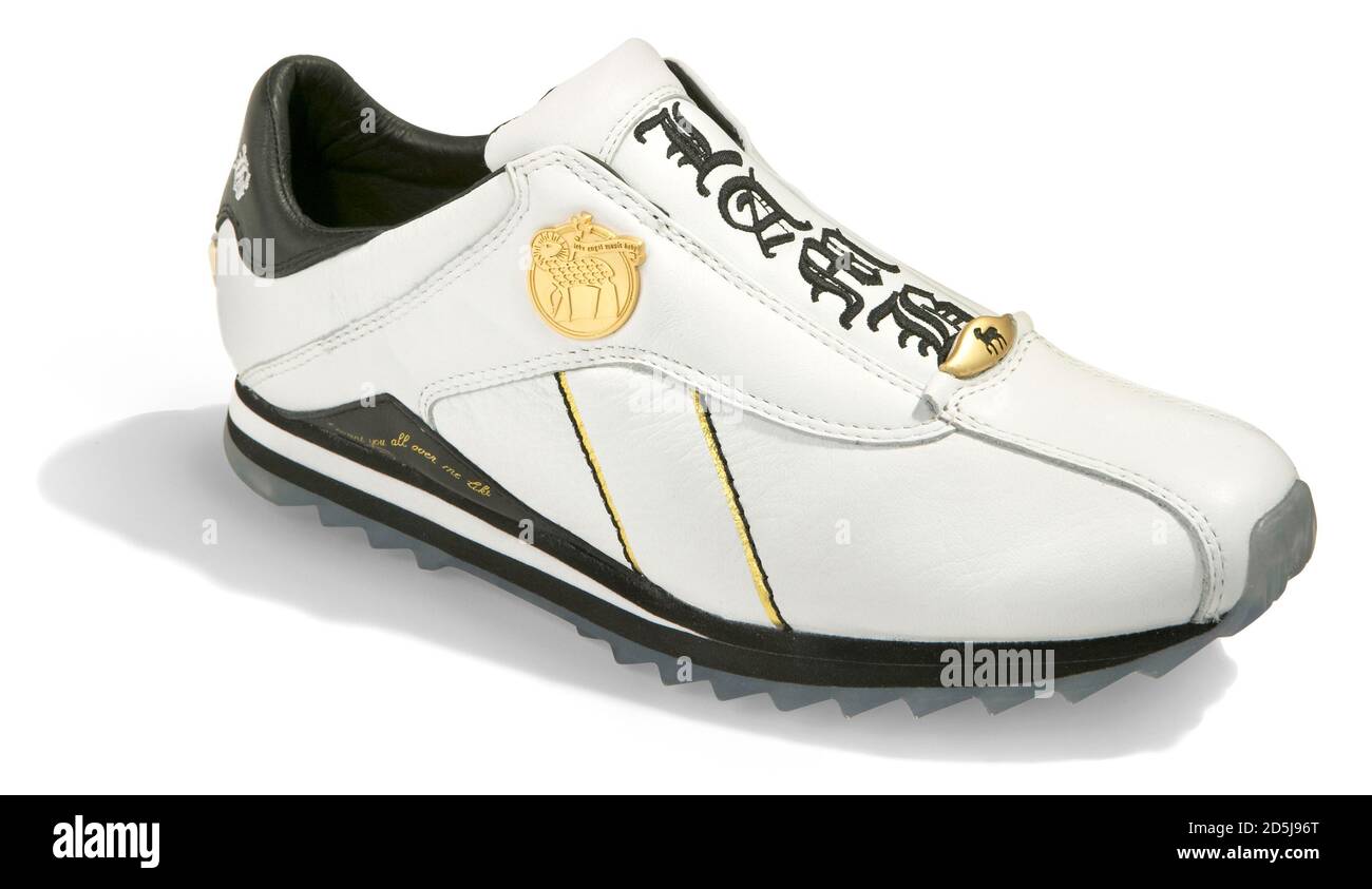 Sneaker noire et blanche L.A.M.B. avec emblème or et lettres brodées photographiées sur fond blanc Banque D'Images