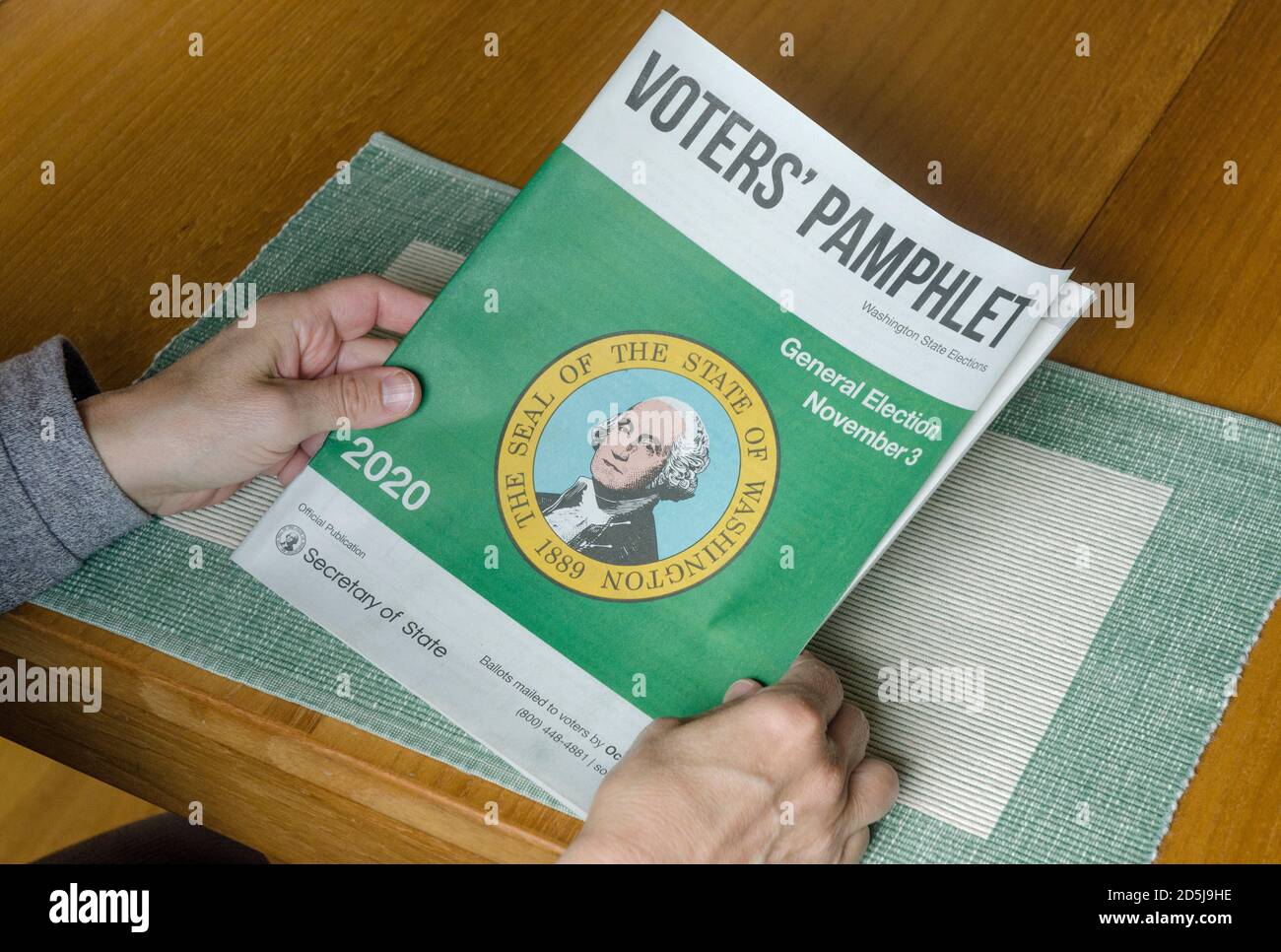 Un électeur tient la brochure des électeurs, qui contient des informations sur les candidats et les mesures à l'échelle de l'État pour le public. Banque D'Images