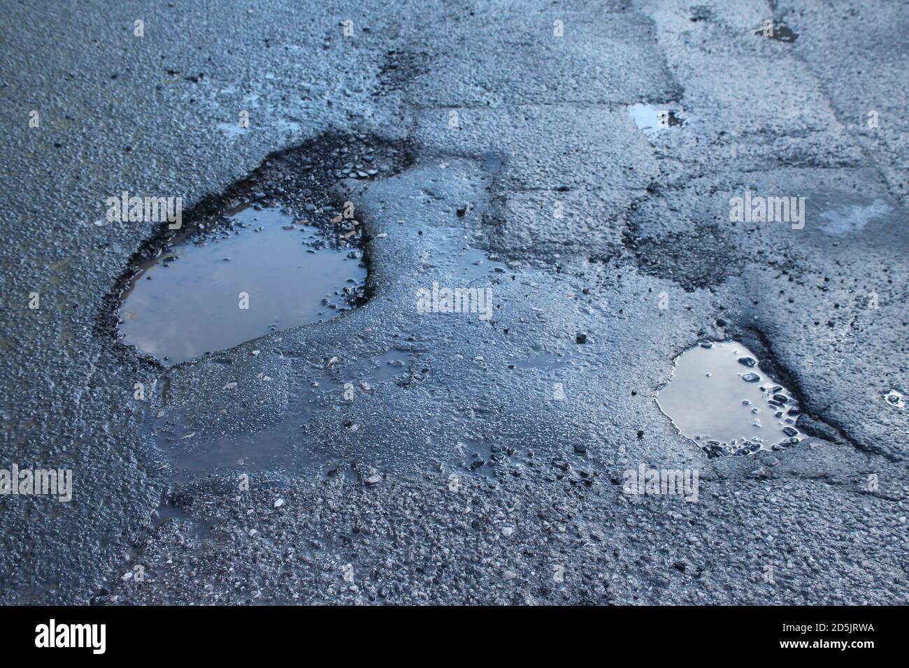 Trous de pot sur la route asphaltée, surface de tarmac Royaume-Uni Banque D'Images