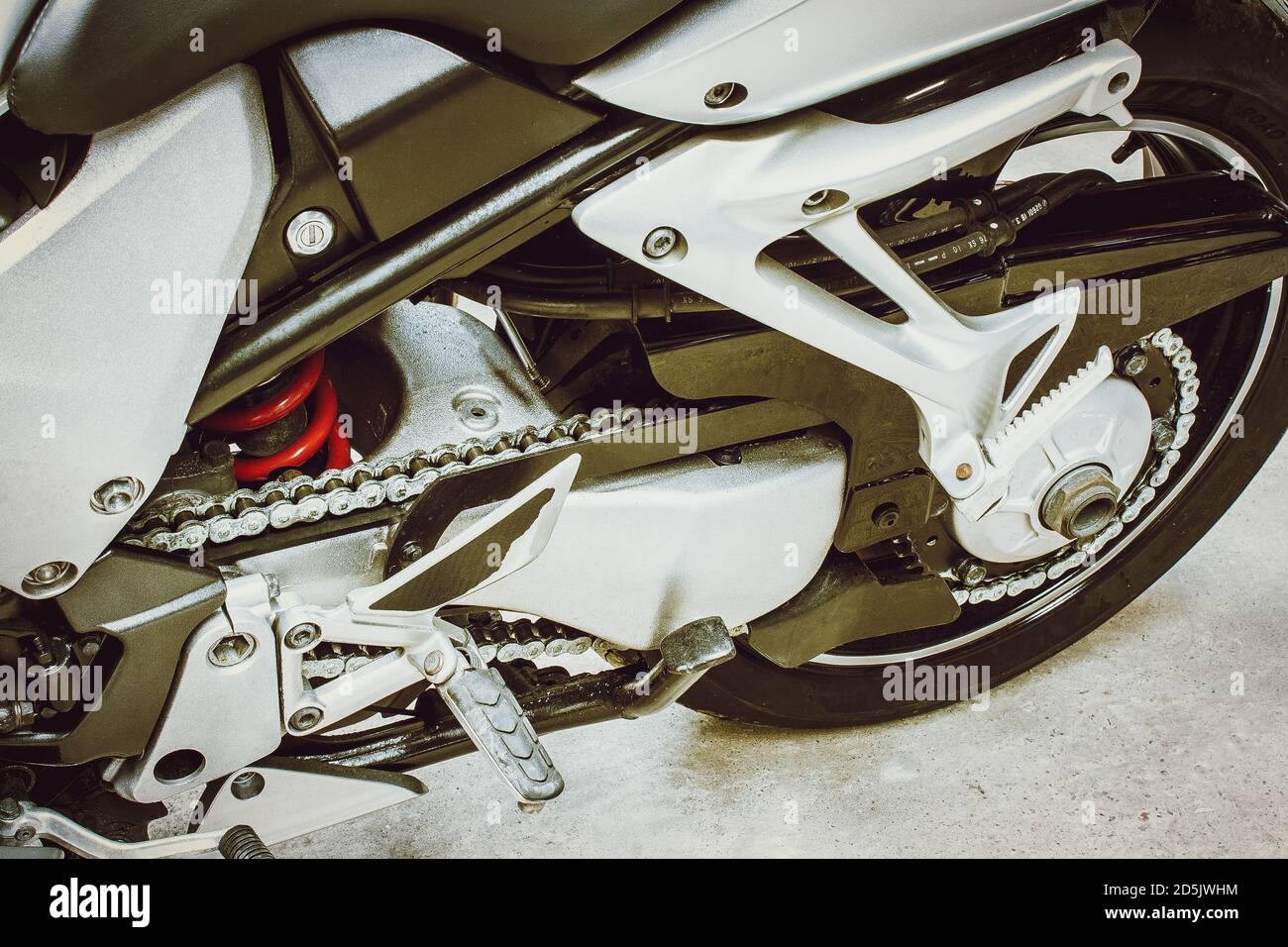 Vue rapprochée de l'arrière de la moto, des pièces de transmission en métal et en chrome. Roue arrière, cadre en fer, chaîne, disque, ressort de sportbike dans une photo de couleur à angle bas en g Banque D'Images