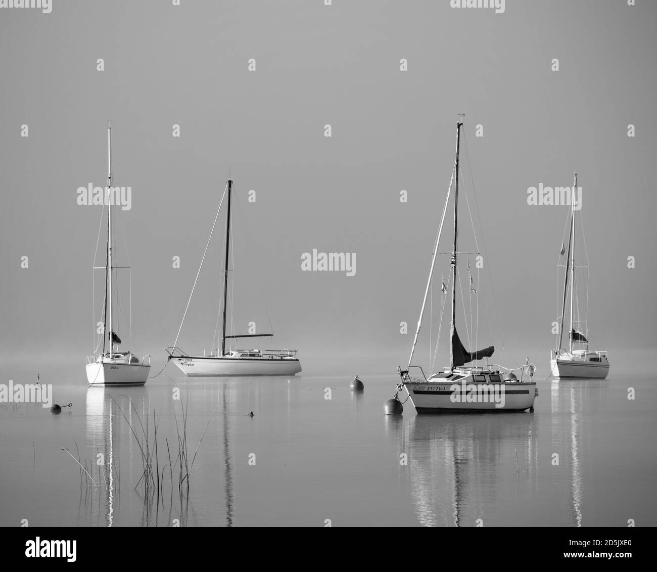 Lac brumeux avec des bateaux isolés - Mondsee, Autriche Banque D'Images