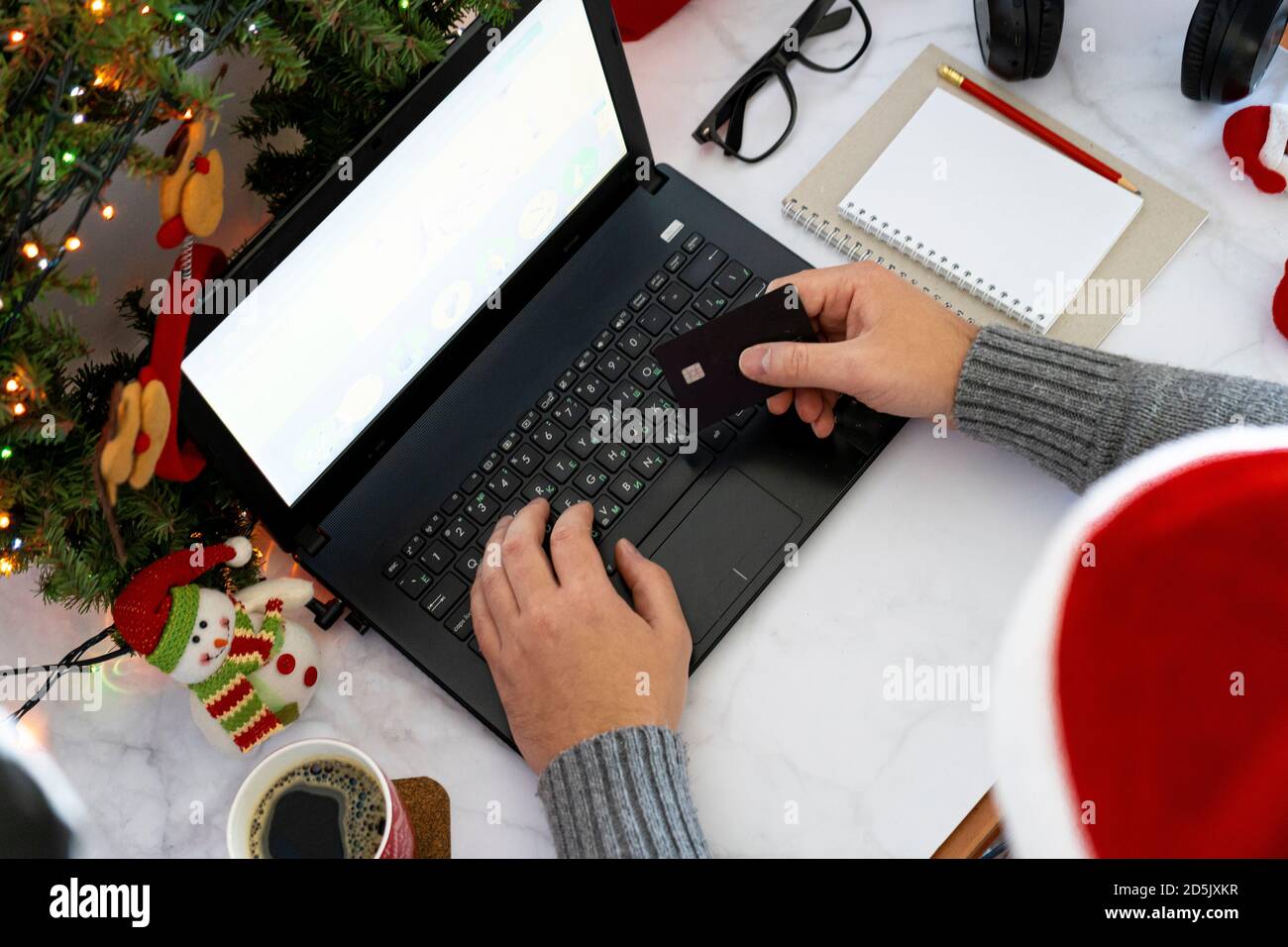 Achats en ligne de Noël. Achat de biens et de cadeaux pour la nouvelle année par Internet. Écrivez une liste et tenez une carte de crédit. Bureau avec ordinateur portable Banque D'Images