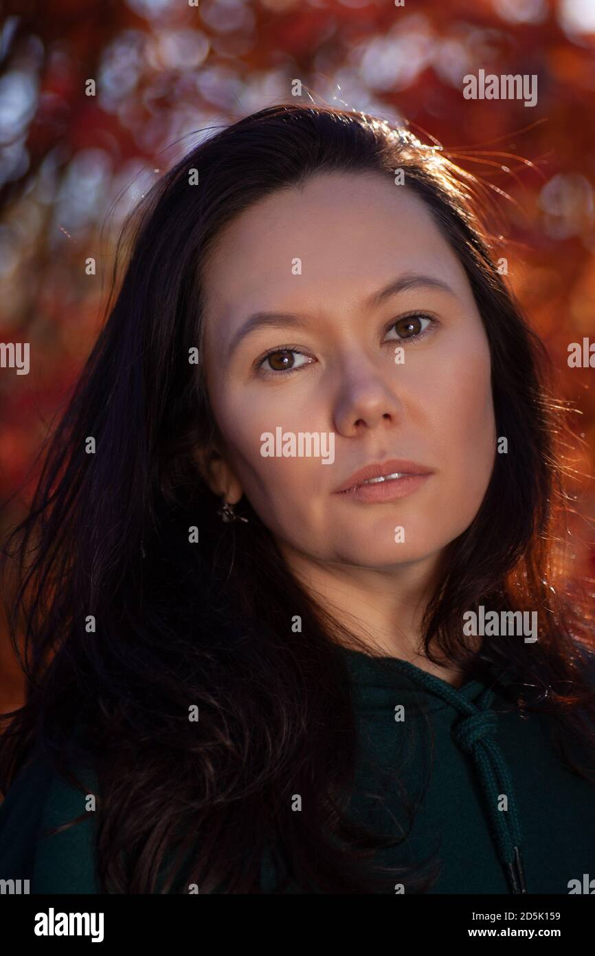 Portrait d'une belle jeune femme asiatique dans une forêt d'automne rouge au coucher du soleil, gros plan Banque D'Images