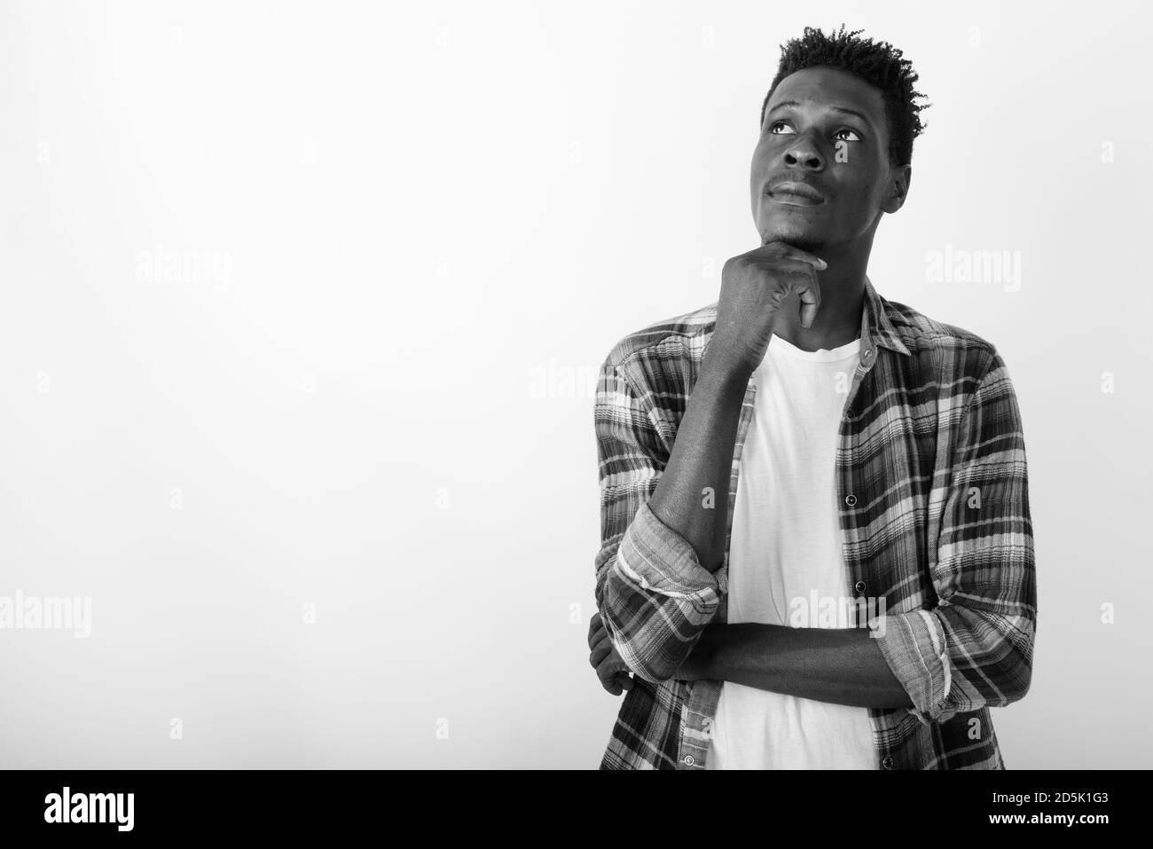 Studio shot of young black African man thinking with hand on chin contre fond blanc Banque D'Images