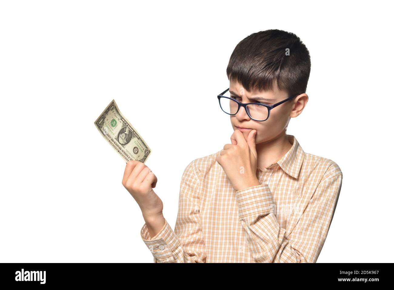 Un jeune garçon tient une facture d'un dollar et pense quoi pour le dépenser Banque D'Images