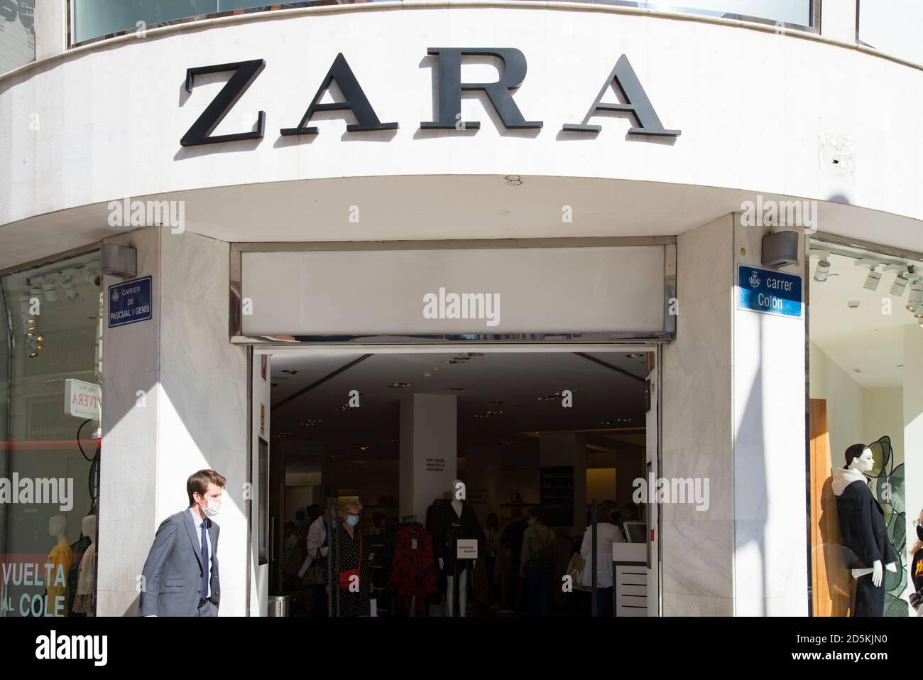 Un homme portant un masque passe devant le magasin Zara Photo Stock - Alamy