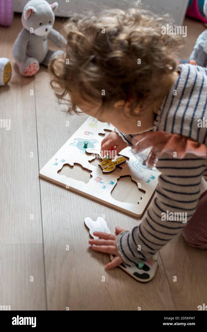 enfant de 17 mois jouant avec un puzzle en bois, des formes d'animaux Banque D'Images