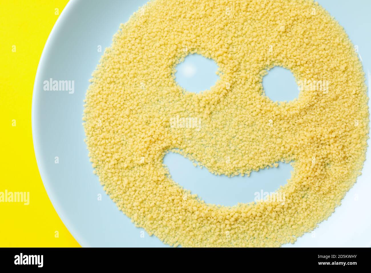 Sourire fait de couscous dans l'assiette sur fond jaune Photo Stock - Alamy