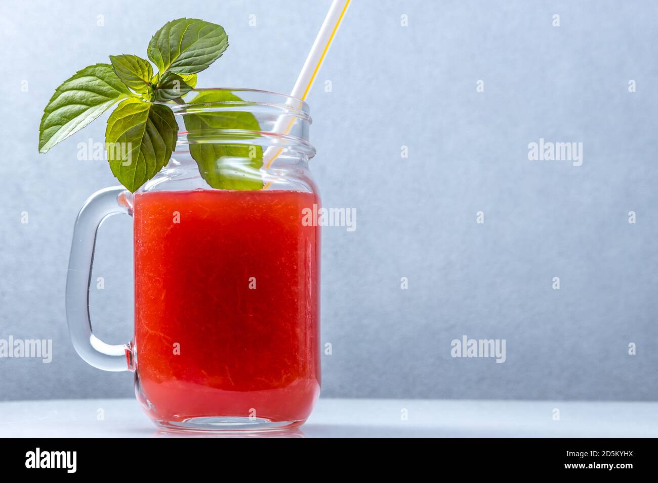 Smoothie au melon d'eau dans un pot avec des feuilles de menthe et un paille cocktail Banque D'Images