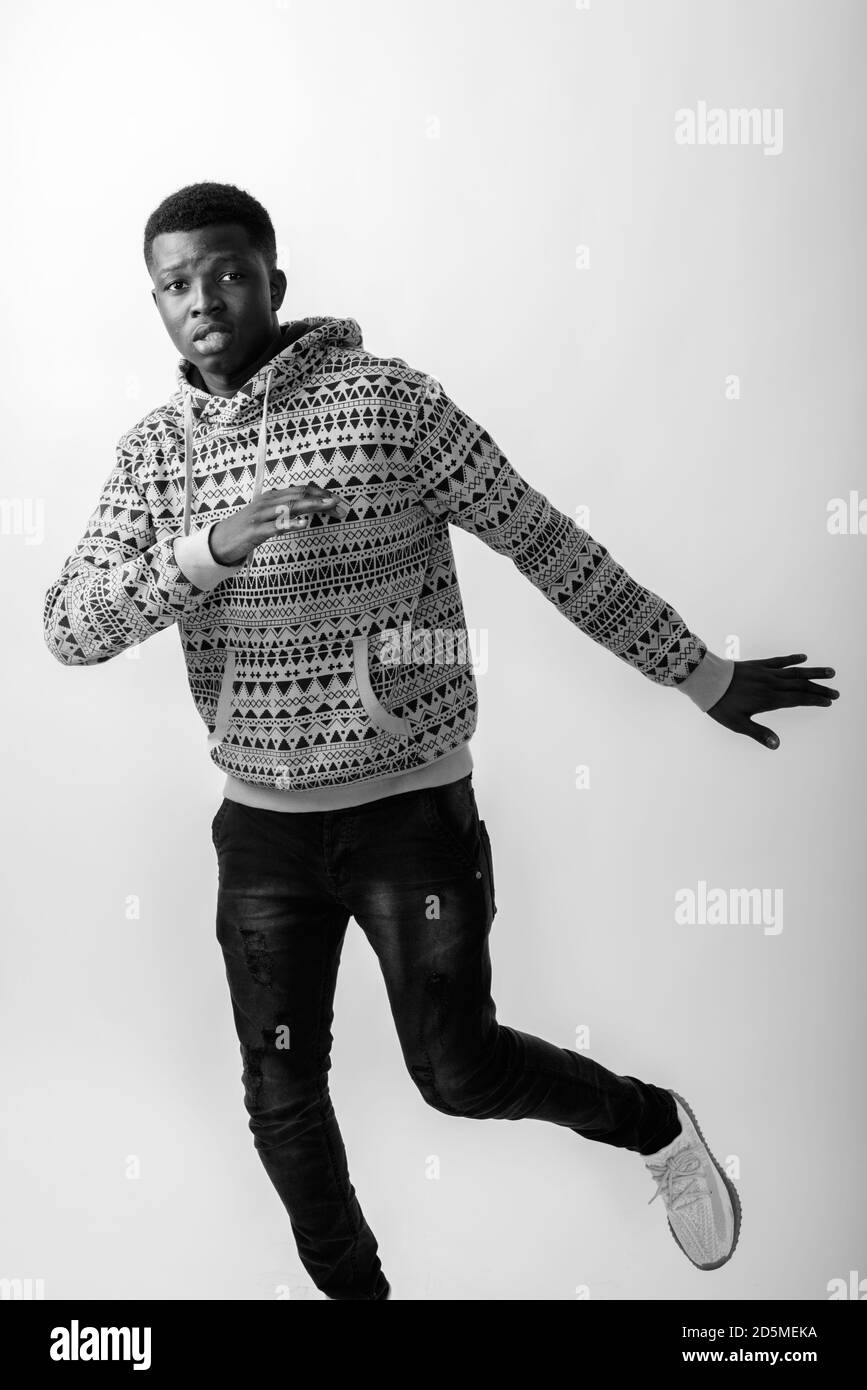 Photo en studio d'un jeune homme africain noir debout en posant avec la ...