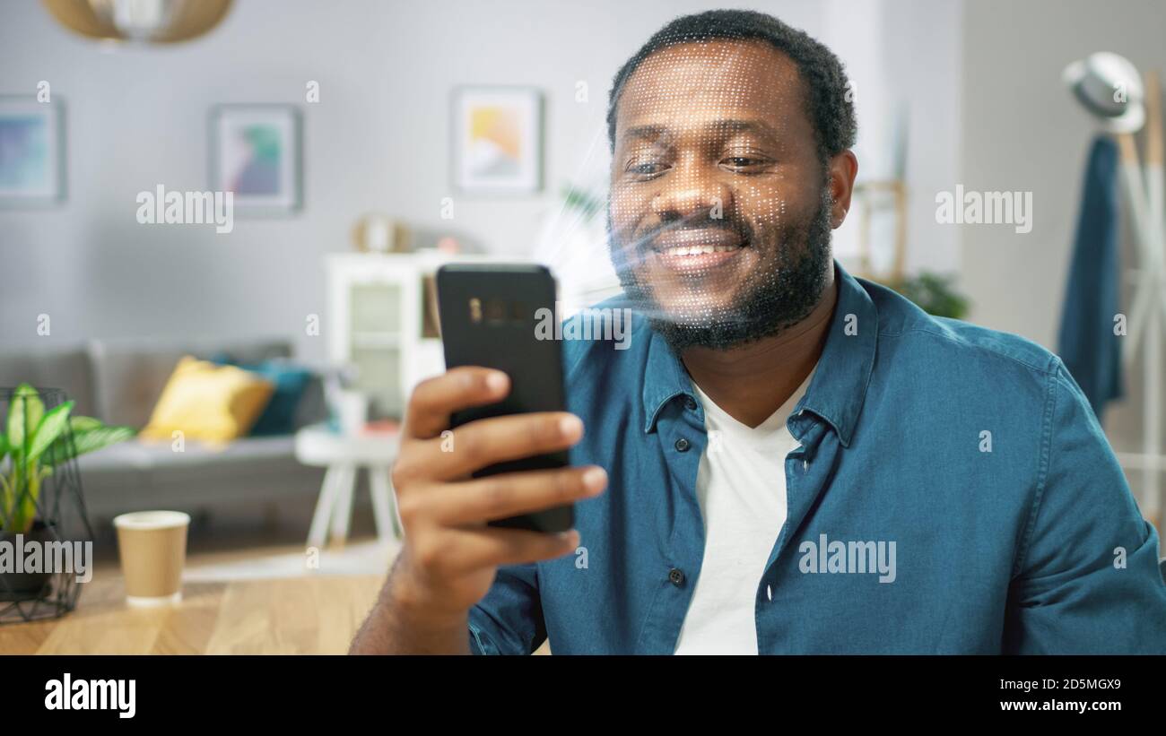Jeune homme identifié par la reconnaissance faciale biométrique processus de lecture à partir de son smartphone. Concept futuriste : le projecteur identifie l'individu par Banque D'Images