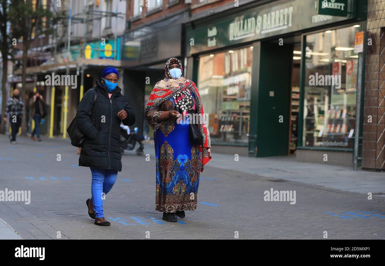 Les personnes portant un masque facial dans le centre-ville de Nottingham, après que le Premier ministre Boris Johnson ait établi un nouveau système à trois niveaux d'alerte pour l'Angleterre après la hausse des cas de coronavirus et des admissions à l'hôpital. Banque D'Images