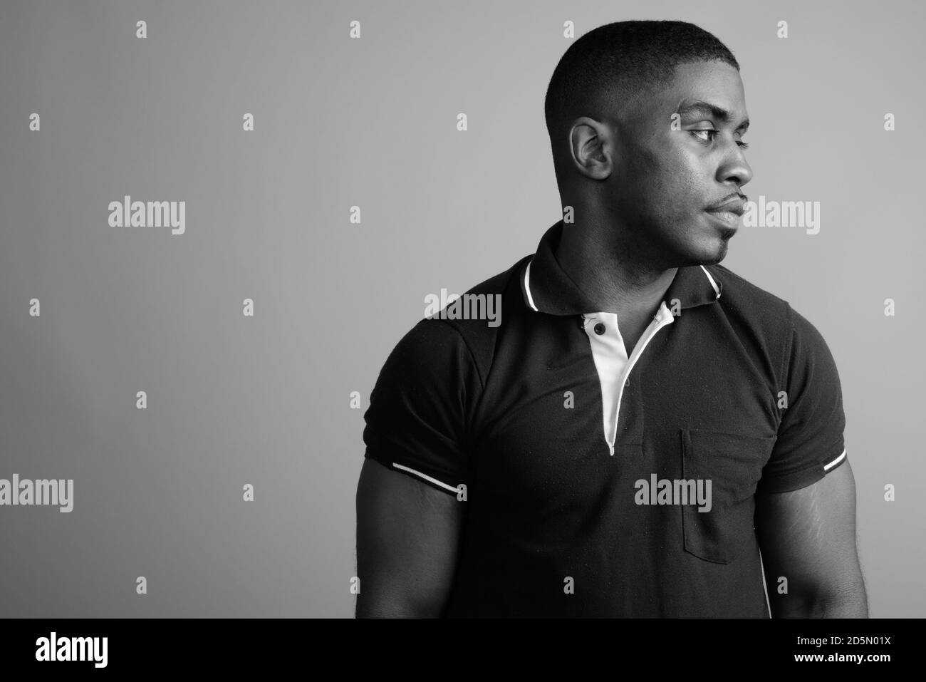 Beau jeune homme africain contre l'arrière-plan gris Banque D'Images