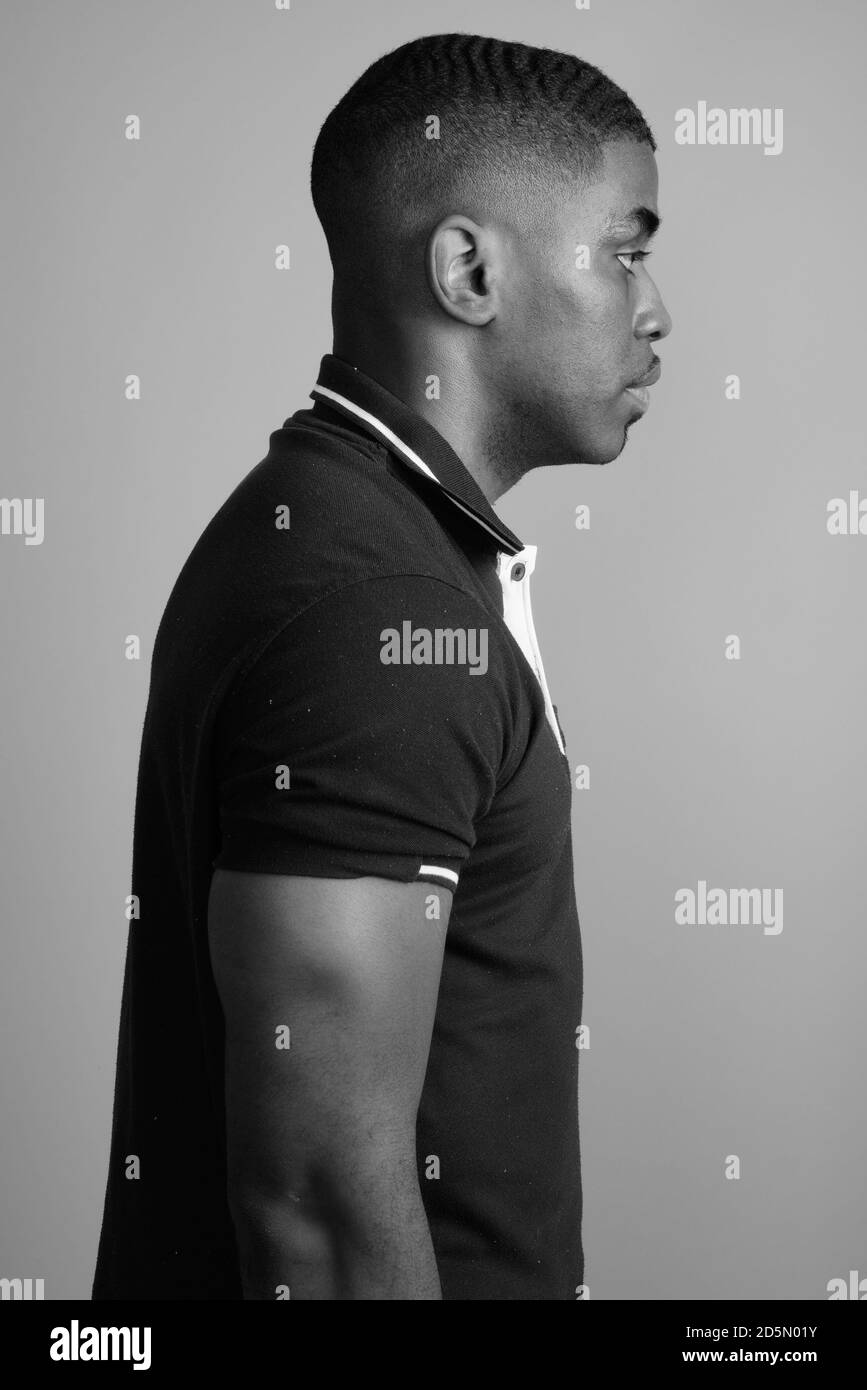 Beau jeune homme africain contre l'arrière-plan gris Banque D'Images
