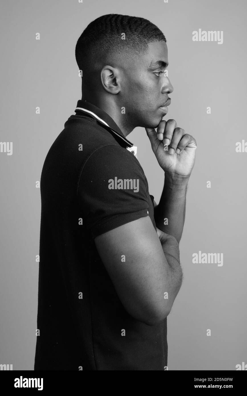 Beau jeune homme africain contre l'arrière-plan gris Banque D'Images