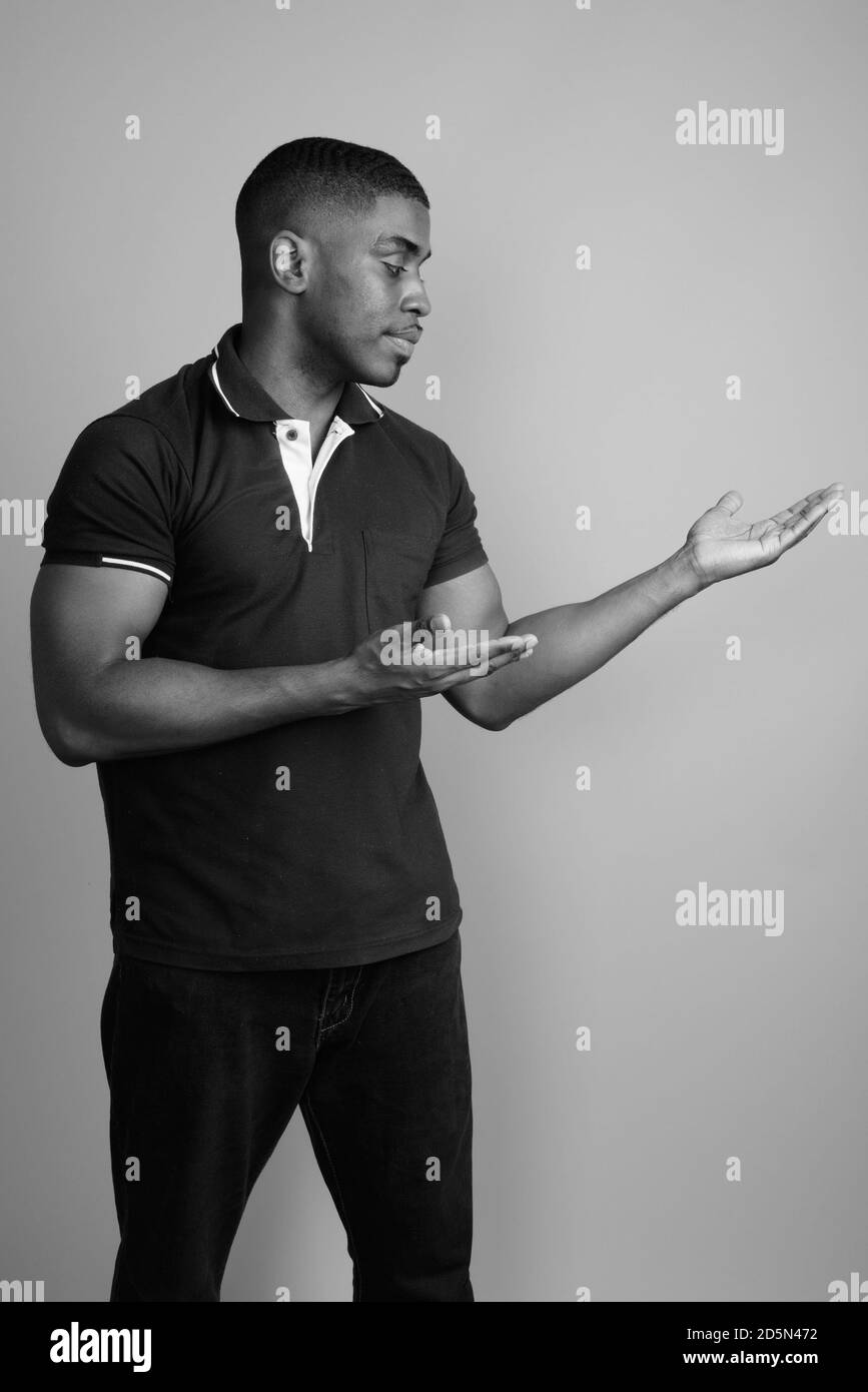 Beau jeune homme africain contre l'arrière-plan gris Banque D'Images