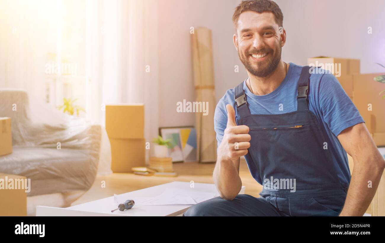 Un ouvrier d'assemblage de meubles réussit à terminer l'assemblage de la tablette et montre les écumils en haut de façon douce. Professionnel Handy fait bien le travail d'assemblage. Salle éclairée Banque D'Images