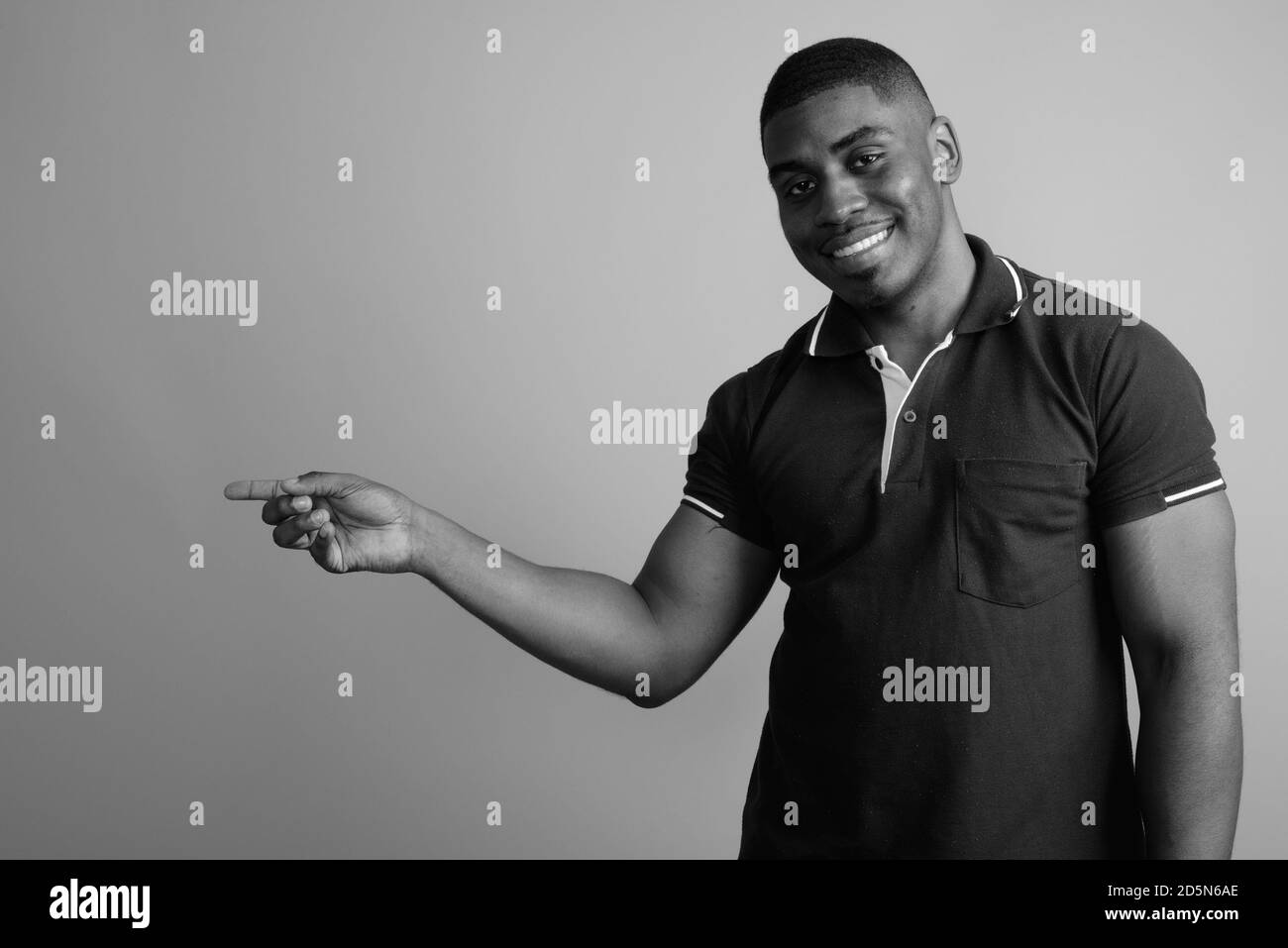 Beau jeune homme africain contre l'arrière-plan gris Banque D'Images