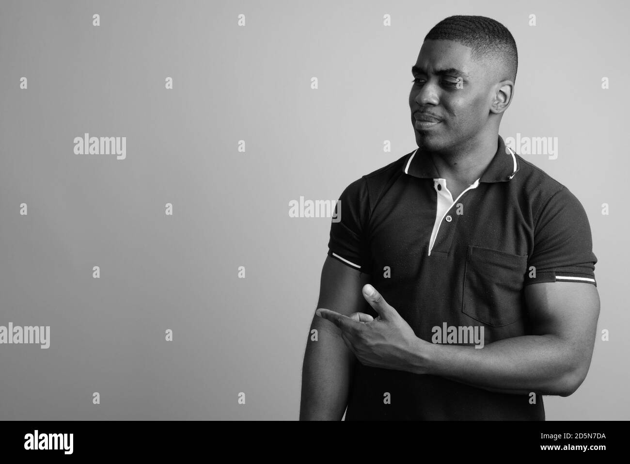 Beau jeune homme africain contre l'arrière-plan gris Banque D'Images