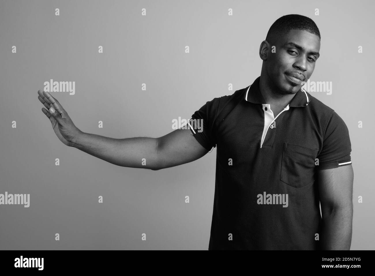 Beau jeune homme africain contre l'arrière-plan gris Banque D'Images