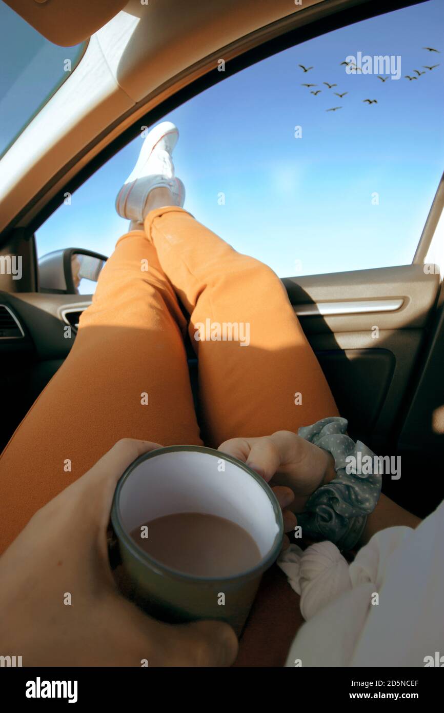 Femme détendue appréciant son café dans une voiture Banque D'Images