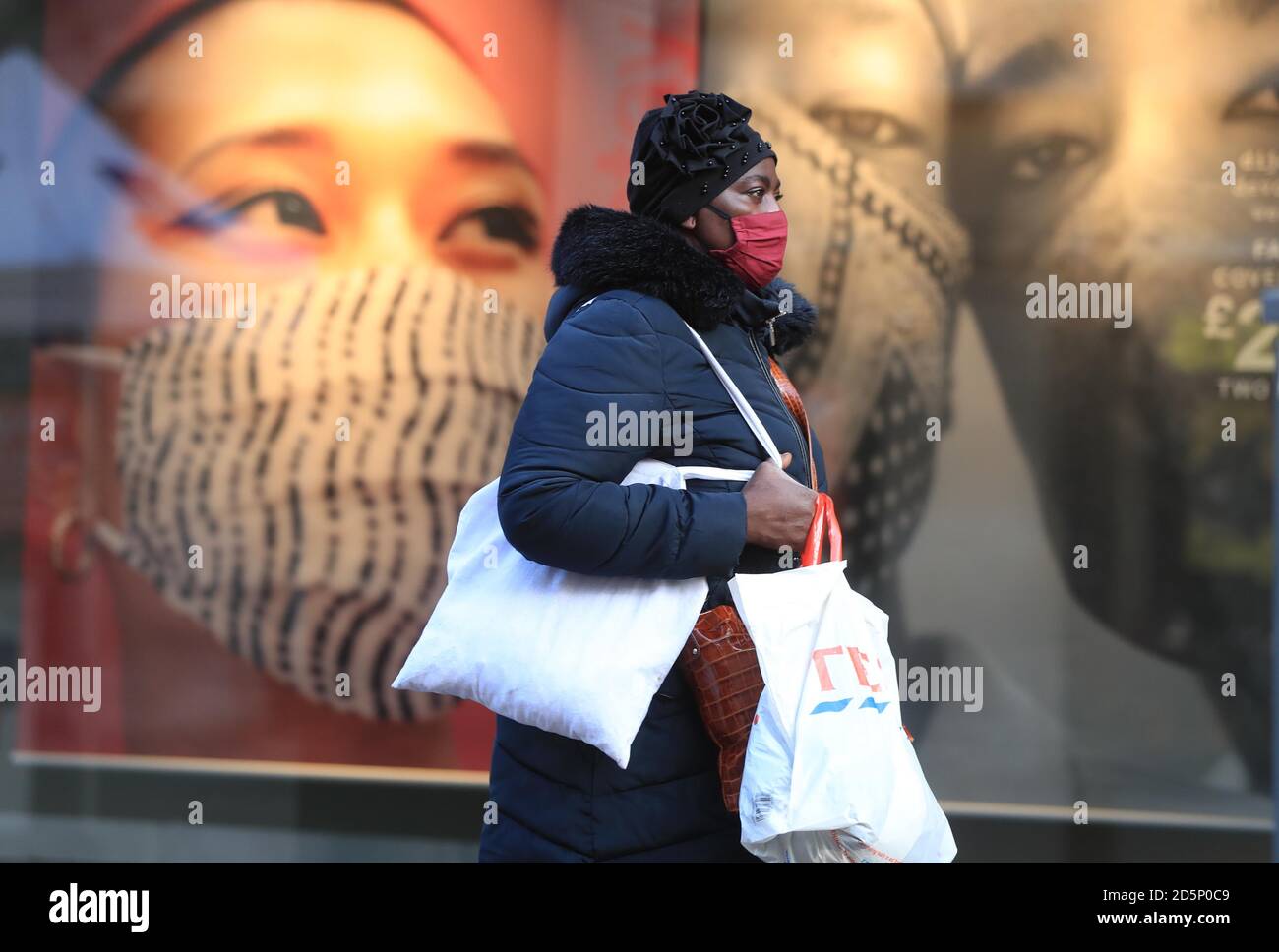 Une femme portant un masque facial dans le centre-ville de Nottingham, après que le Premier ministre Boris Johnson ait établi un nouveau système à trois niveaux d'alerte pour l'Angleterre après la hausse des cas de coronavirus et des admissions à l'hôpital. Banque D'Images