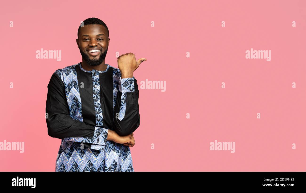 Rire homme noir en costume africain pointant vers l'espace libre Banque D'Images