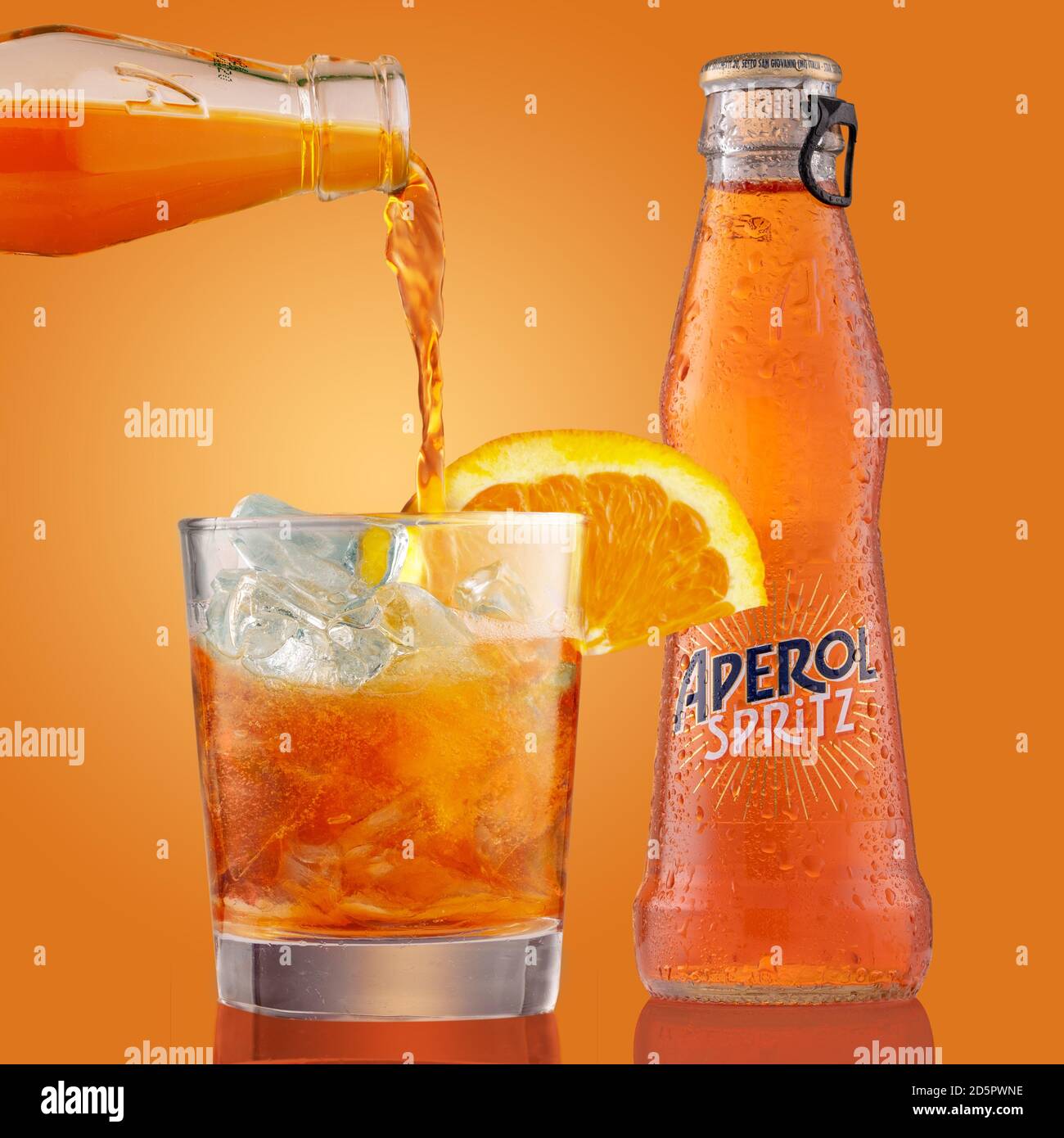 Bouteille et verre de cocktail aperol Spritz avec tranche d'orange. Le  barman verse aperol spritz en verre rempli de glaçons. Liqueur sur orange  Photo Stock - Alamy