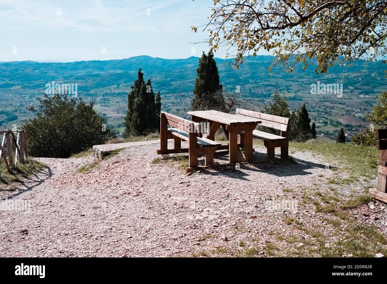 Une table de pique-nique en bois vide avec bancs en bois dans un parc avec vue panoramique (Gubbio, Ombrie, Italie, Europe) Banque D'Images