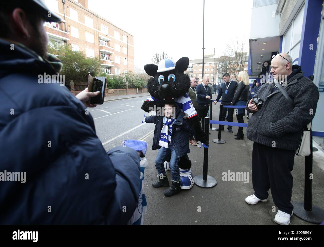 Un jeune fan de QPR a pris sa photo avec une mascotte Jude à l'extérieur du stade Loftus Road Banque D'Images