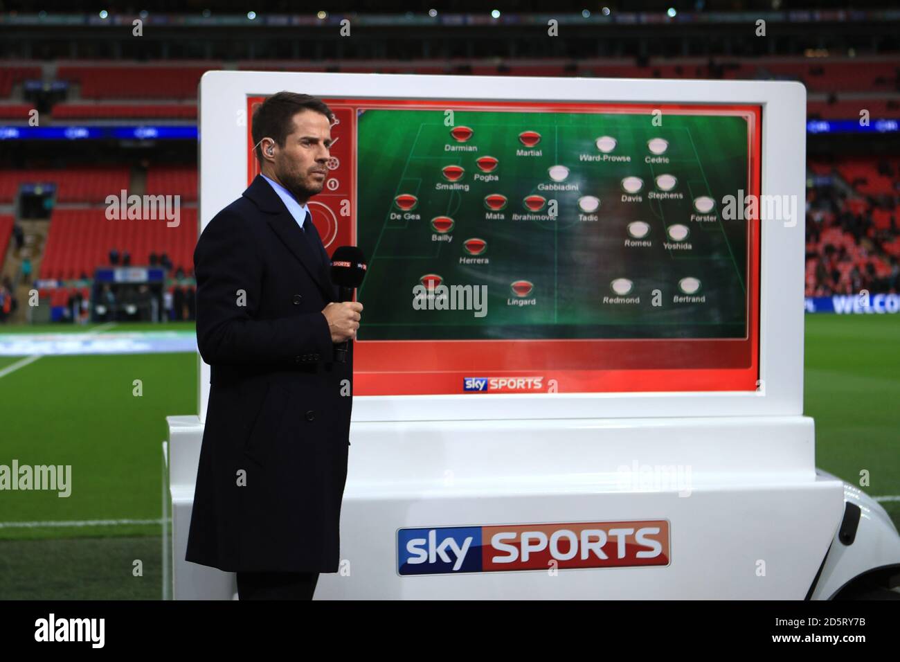 Jamie Redknapp rapporte le côté de la pelouse le long du mobile SKY Sports Avec les équipes qui y sont présentes pendant la coupe EFL Match final entre Manchester United et Southampton au stade Wembley Banque D'Images