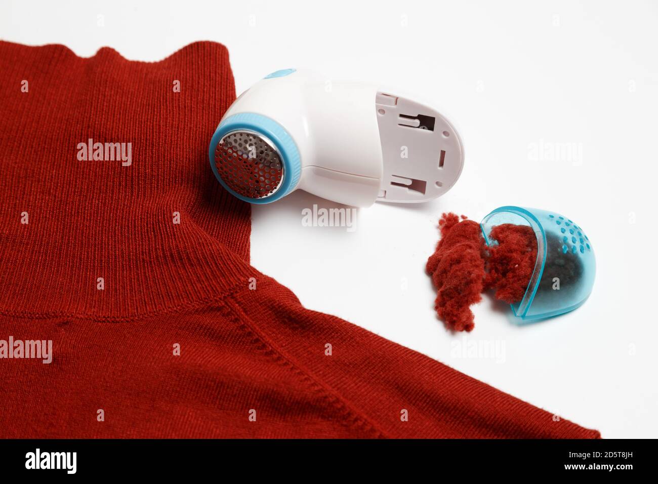 Dispositif d'élimination des peluches des vêtements en laine. Golf avec boule de fuzz isolée sur fond blanc. Banque D'Images