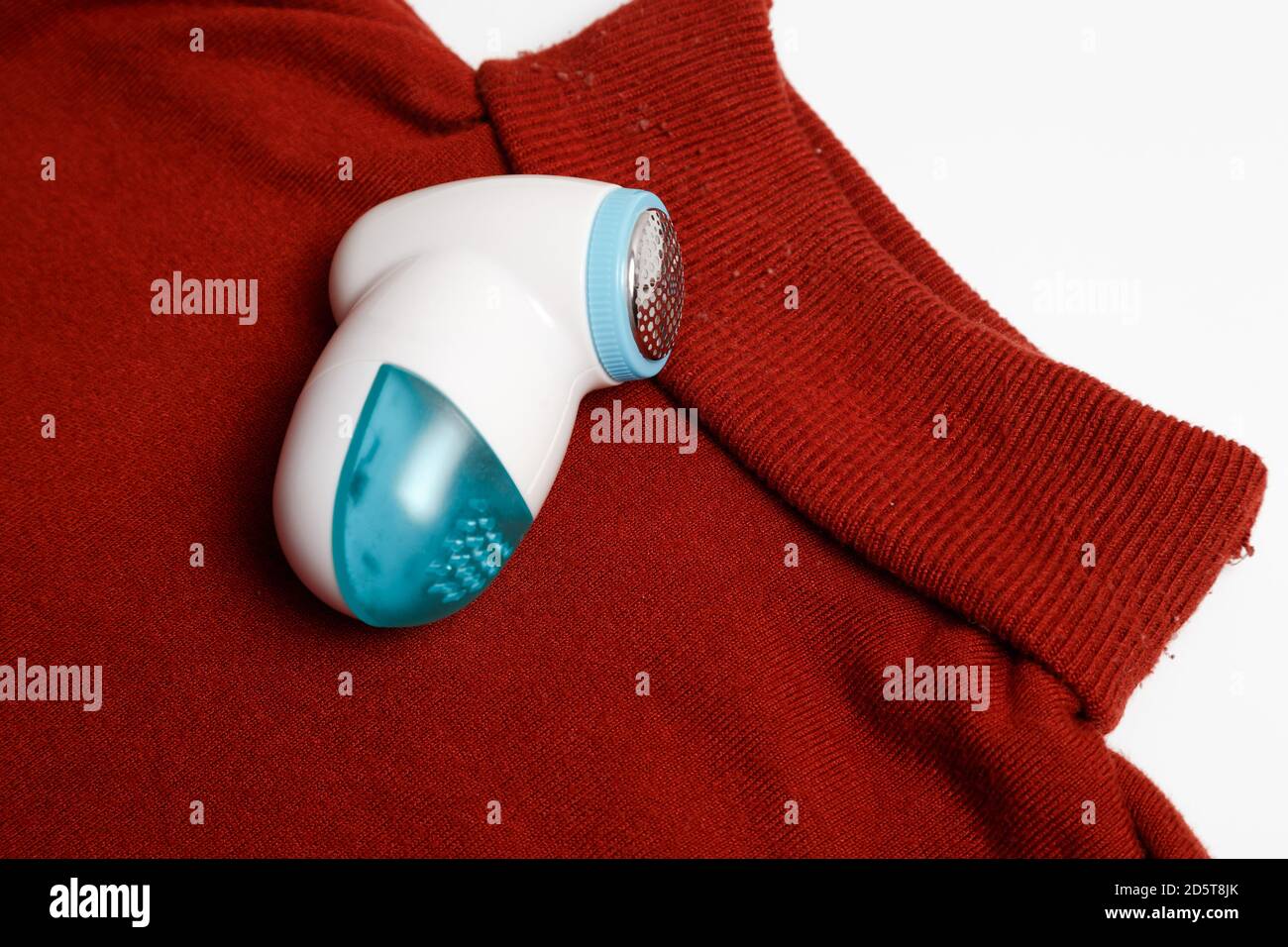 Dispositif d'élimination des peluches des vêtements en laine. Golf avec boule de fuzz isolée sur fond blanc. Banque D'Images