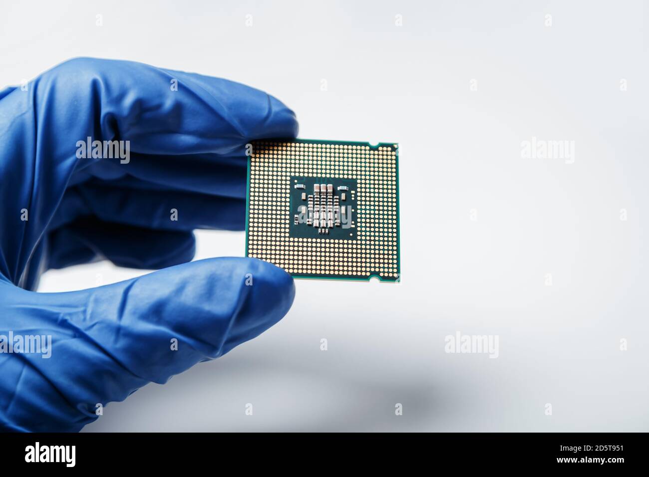 Gros plan sur une nouvelle puce à semi-conducteurs dans la main gantée d'un informaticien. Technologie moderne et développement de matériel Banque D'Images