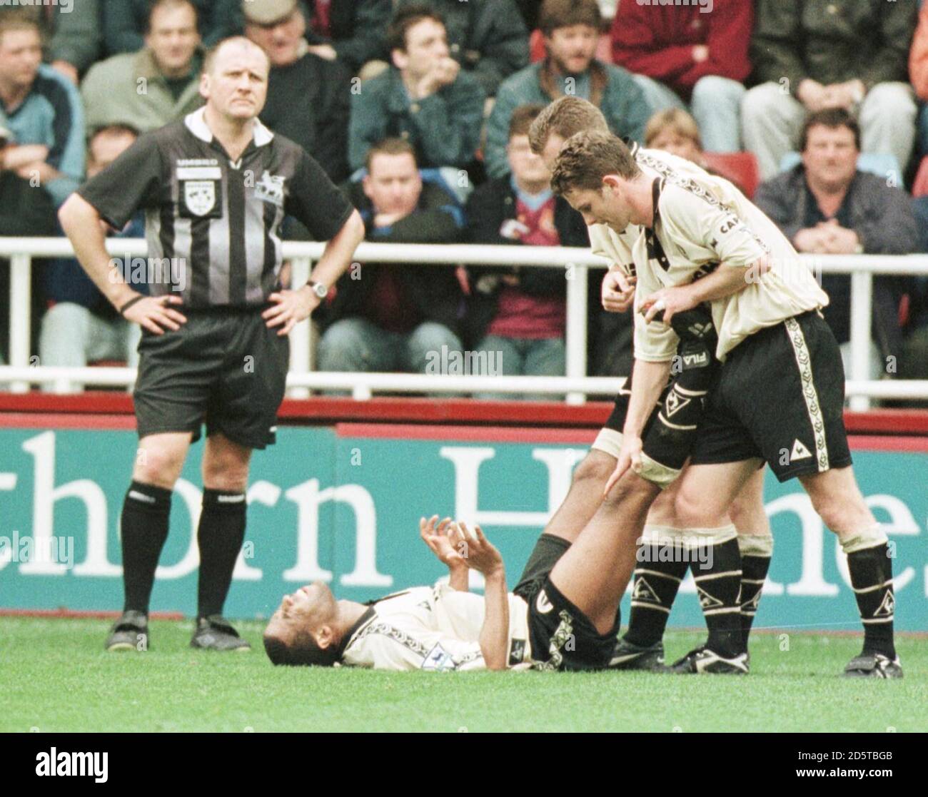 Mark Kinsella (à droite) et Graham Stuart (à droite, caché) de Charlton Athletic traitent l'équipier John Barnes (à gauche) pour le camp Banque D'Images