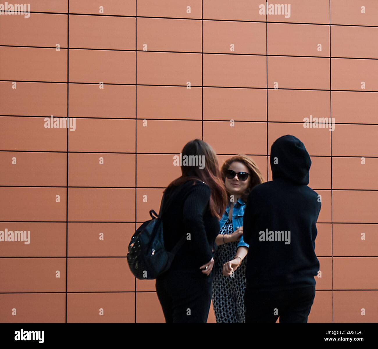 Trois filles parlent dans la rue. Banque D'Images