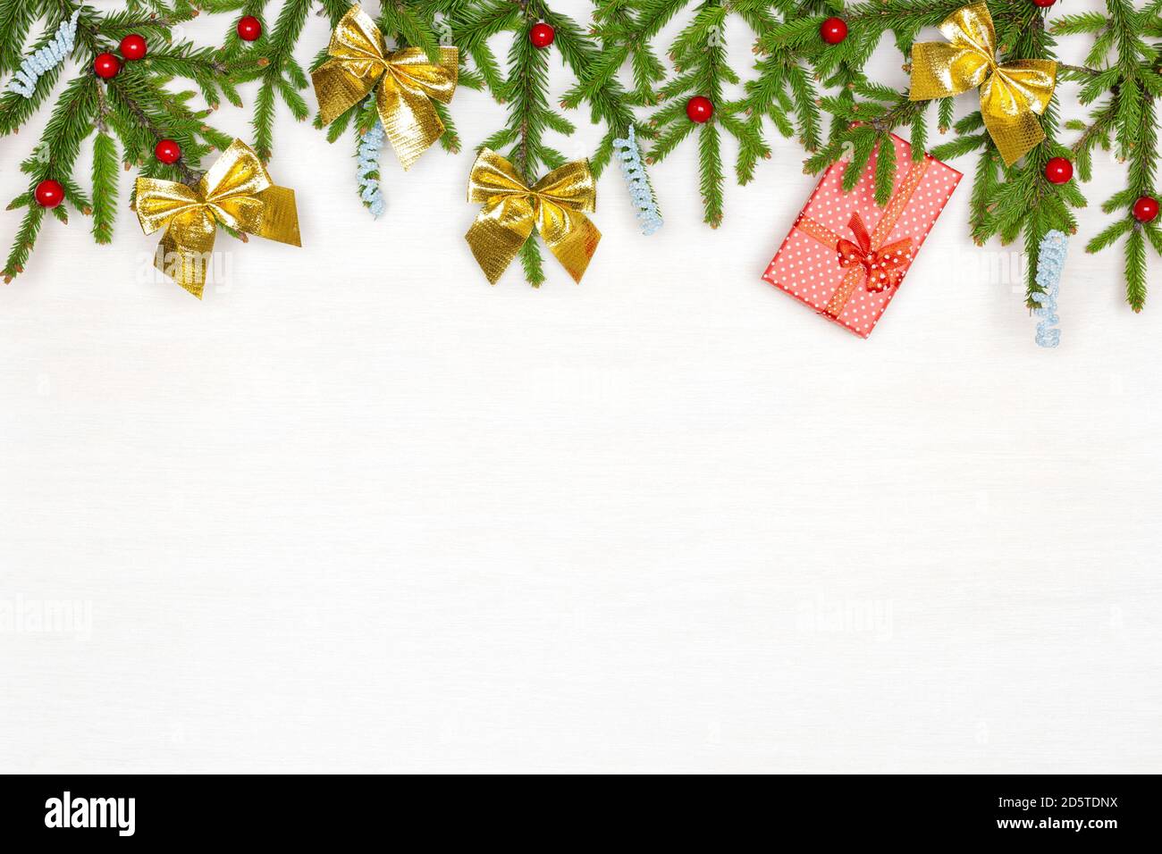 Branches d'arbre de Noël vert naturel décorées avec boîte cadeau rouge sur bois peint en blanc. Copier l'espace. Arrière-plan de Noël Banque D'Images