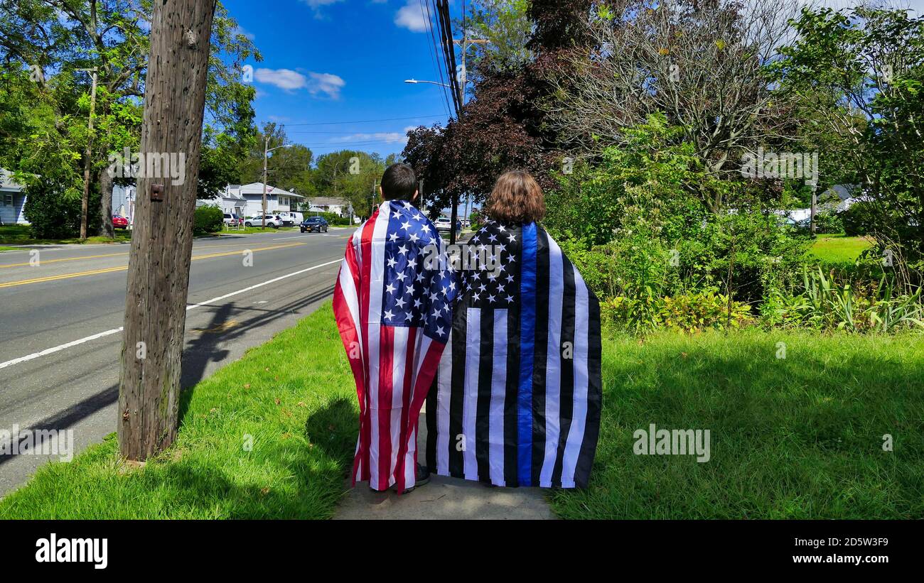 Lindenhurst, New York, septembre 2020 - deux personnes debout, avec des drapeaux sur le dos, un drapeau américain et l'autre un drapeau de ligne bleue mince, pendant une Parade de matière de vies bleues. Photo de haute qualité Banque D'Images