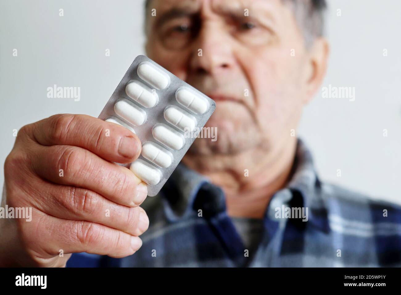 Homme âgé avec des pilules blanches en blister, traitement du coronavirus et prévention. Concept de prescription médicale, le rhume et la grippe Banque D'Images