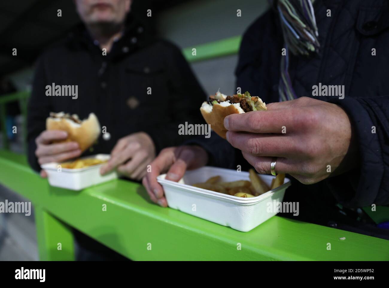 Les fans mangent un hamburger végétarien dans les stands Banque D'Images