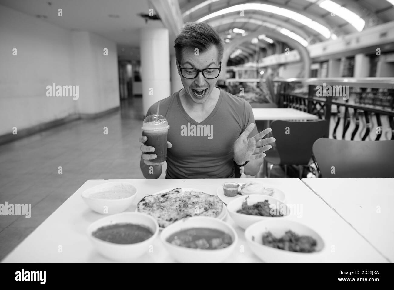 Jeune homme de tourisme charmant qui apprécie la cuisine indienne au restaurant Banque D'Images