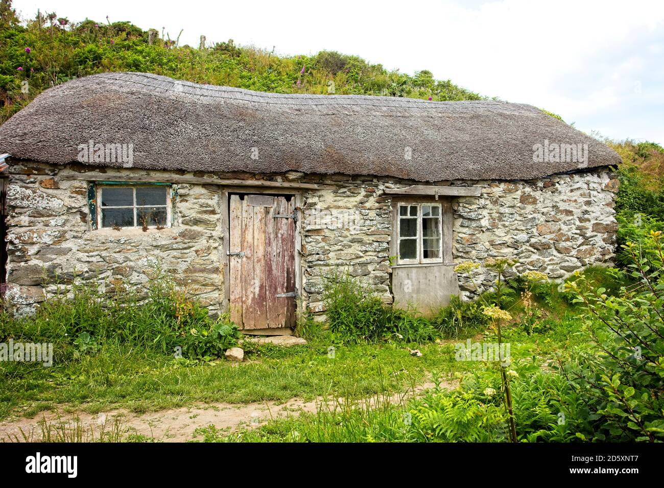 Une ancienne cabane de pêcheur au chaume, Prussia Cove, Cornouailles, Angleterre, Royaume-Uni. Banque D'Images