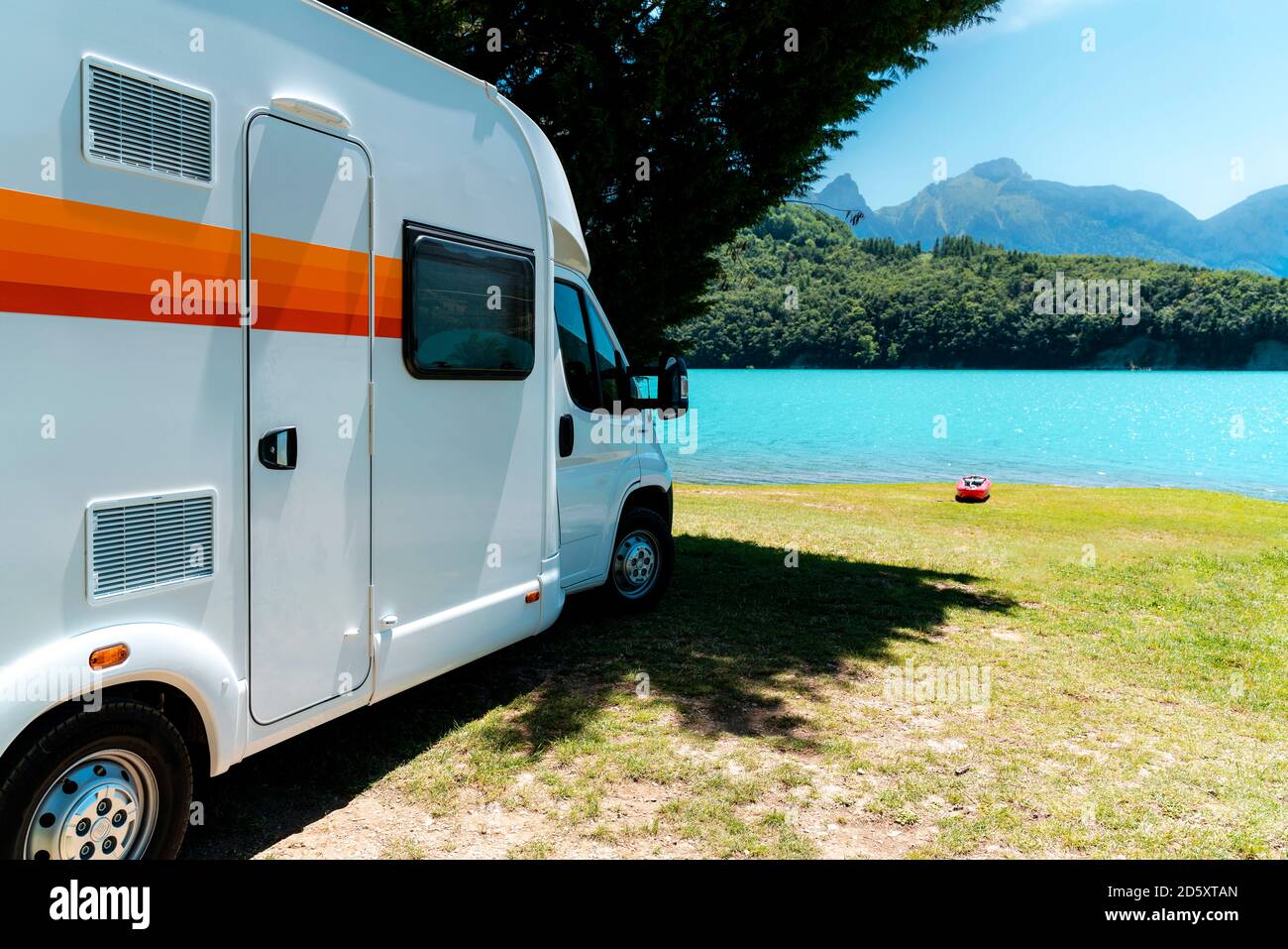 Camping camping-car en face d'un lac bleu avec des montagnes Et un kayak  rouge Photo Stock - Alamy