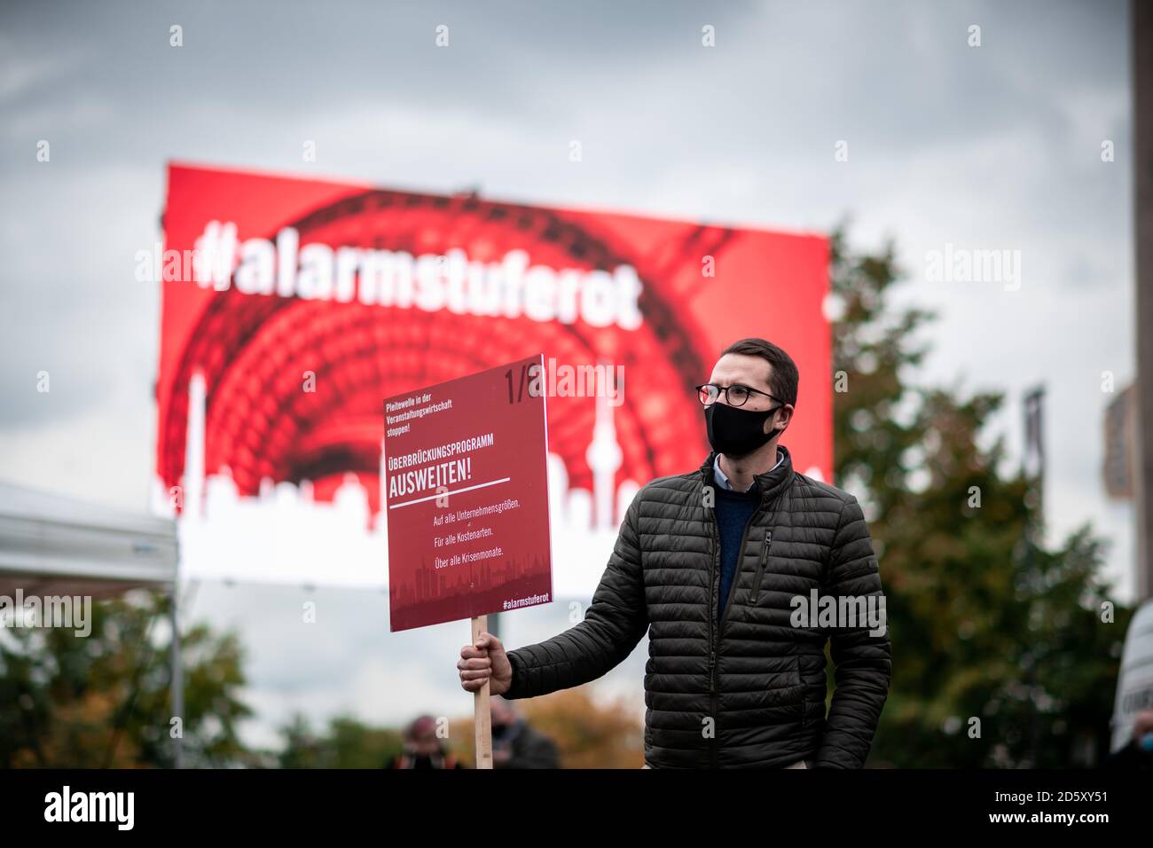 Düsseldorf, Allemagne. 14 octobre 2020. Un participant à la démonstration est muni d'un panneau en face d'un présentoir indiquant '#alarmstuferot'. L'alliance #AlarmstufeRot organise une manifestation et un rassemblement devant le Parlement de l'État à Düsseldorf. L'industrie allemande des événements a été particulièrement durement touchée par la pandémie de Corona, la fin des restrictions n'est pas en vue. La pandémie de corona devient de plus en plus un problème pour les grandes villes et agglomérations de Rhénanie-du-Nord-Westphalie. Credit: Fabian Strauch/dpa/Alay Live News Banque D'Images