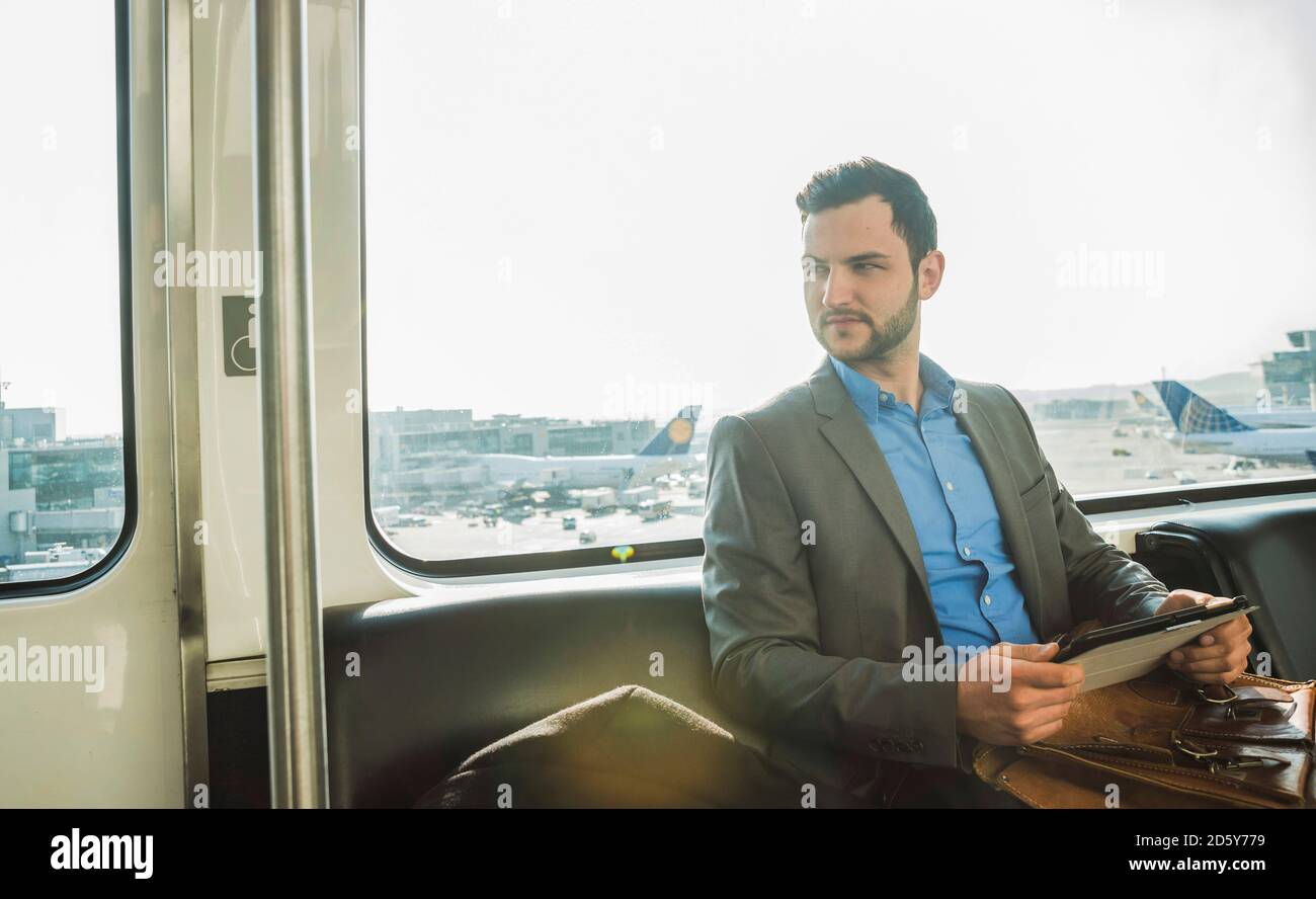 Allemagne, Francfort, jeune homme d'affaires en bus à l'aéroport Banque D'Images