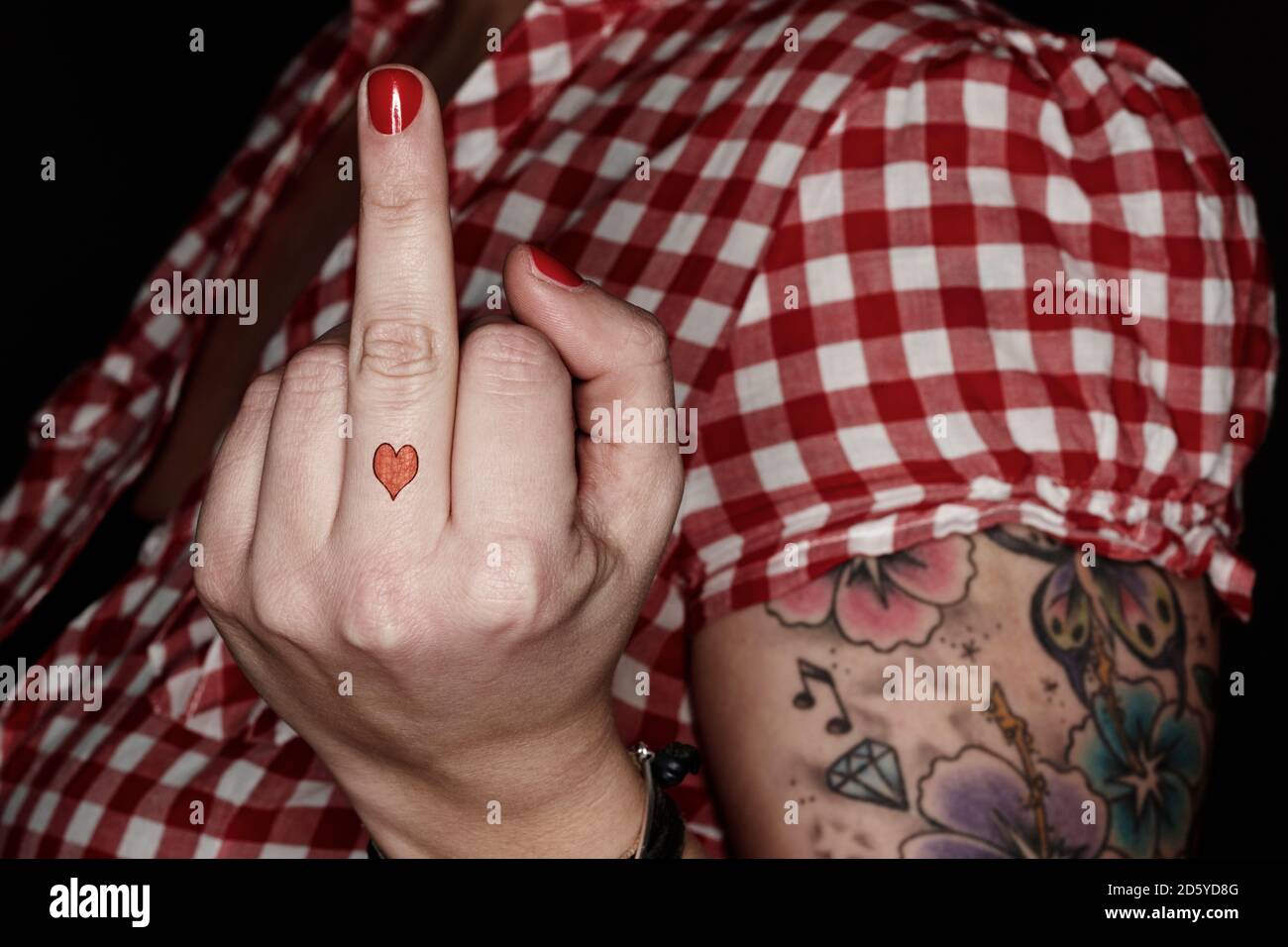 Femme avec tatoos donnant le doigt Banque D'Images