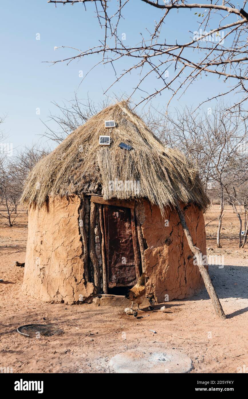 La Namibie, Damaraland, cabane avec des panneaux solaires sur le toit dans un village Himba Banque D'Images