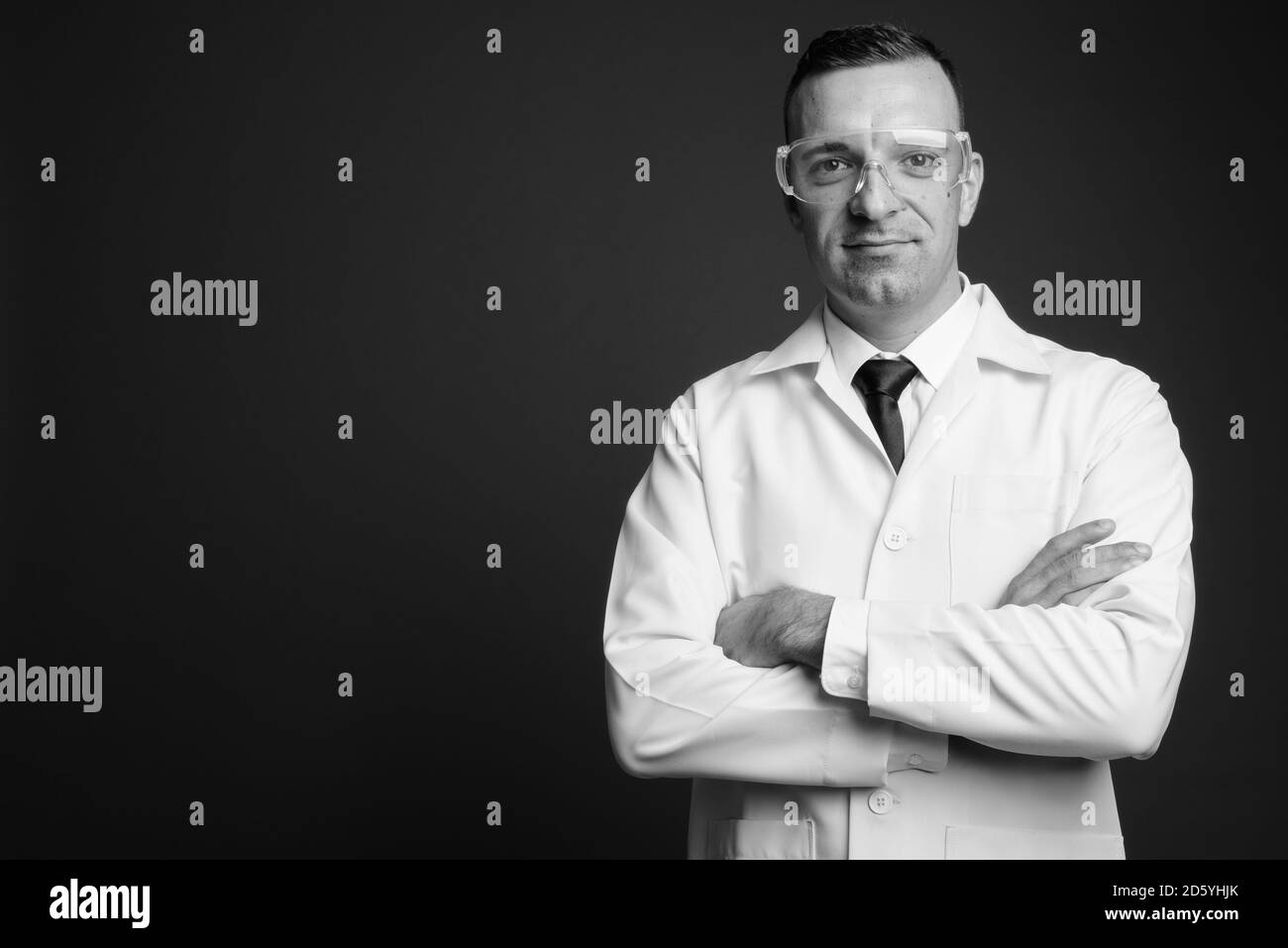 Homme médecin portant des lunettes de protection sur fond gris Banque D'Images